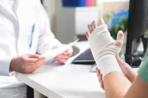 Injured patient showing the doctor a broken wrist