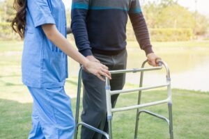 closeup of female nurse helping a man with a walker