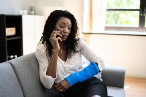 A woman with a bandaged arm is talking with a Virginia Beach dog bite lawyer on the phone.